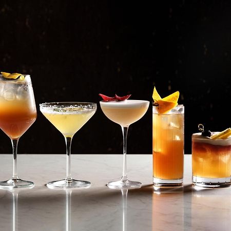 Middle Eight - Covent Garden - Preferred Hotels And Resorts Лондон Екстериор снимка The photo features a selection of five different cocktails lined up on a marble surface. Each drink is served in a distinct glass, showcasing a variety of colors and garnishes. 

1. The first cocktail is in a large wine glass, with a gradient color f
