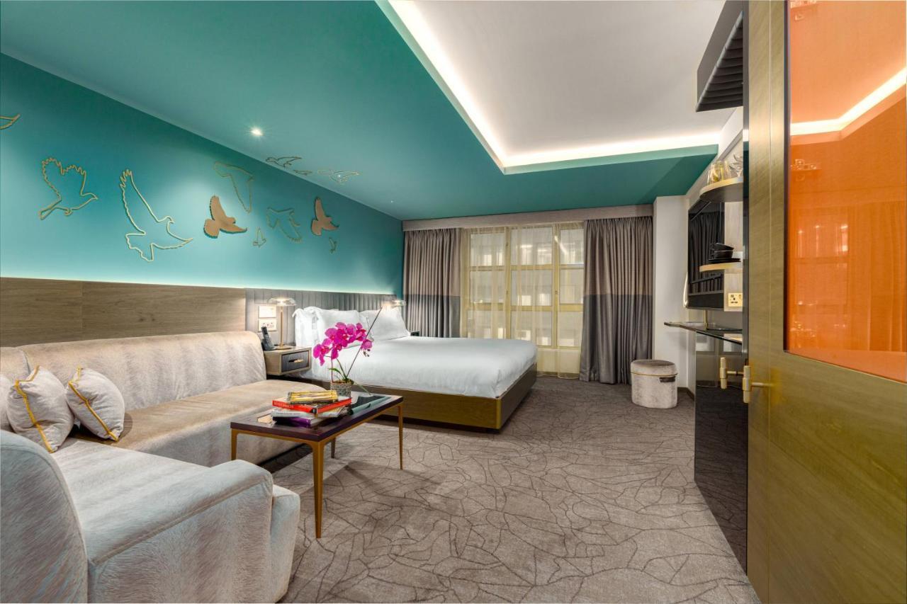 Middle Eight - Covent Garden - Preferred Hotels And Resorts Лондон Екстериор снимка The photo shows a modern hotel room featuring a blend of comfort and style. The room has a light-colored floor with a textured design, and the walls are adorned with a vibrant turquoise accent wall that features decorative butterfly motifs. 

There i