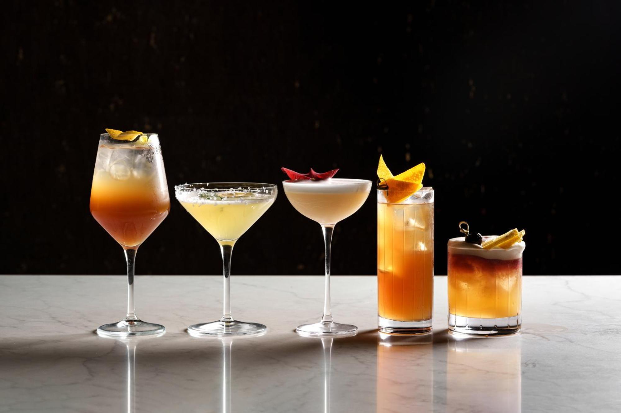 Middle Eight - Covent Garden - Preferred Hotels And Resorts Лондон Екстериор снимка The photo features a selection of five different cocktails lined up on a marble surface. Each drink is served in a distinct glass, showcasing a variety of colors and garnishes. 

1. The first cocktail is in a large wine glass, with a gradient color f
